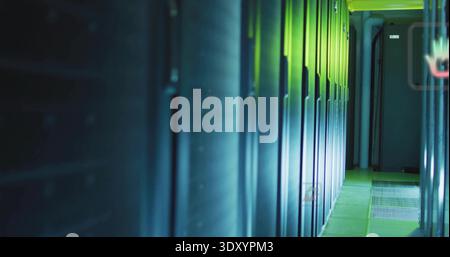 Glowing server cabinets reflecting blue LEDs in data center aisle, revealing floor grates, conduits Stock Photo