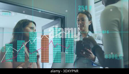 Analyzing three analysts in business attire presenting data on glass partition with tablet laptop Stock Photo