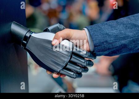 robot and human hands shaking, concept of humanoid and humans interaction and cooperation in the future Stock Photo