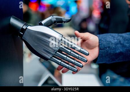 robot and human hands shaking, concept of humanoid and humans interaction and cooperation in the future Stock Photo
