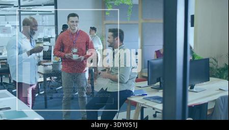 Chatting three male colleagues wearing red sweater and lanyards, holding coffee cups in office Stock Photo
