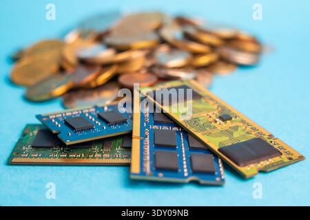 Computer memory modules are shown with coins in the background as demand rises and availability drops in the market for tech products. Stock Photo