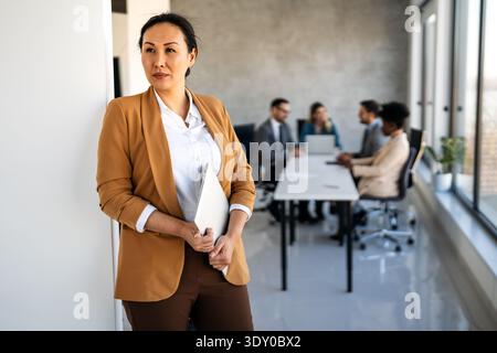 Young happy successful business woman working in corporate office Stock Photo