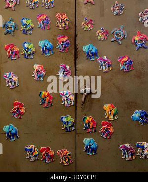 Sri Lankan handcrafted fridge magnets in the shapes of elephants and turtles. The magnets are individually hand-painted with intricate, vibrant motifs. They are crafted from materials like cast poly resin or stone dust. These items are popular souvenirs designed by local artisans to represent Sri Lankan wildlife and culture. The designs often feature a multicolored "mandala" art style. Sri Lanka. Stock Photo