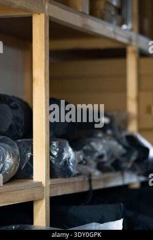 Wooden storage shelves neatly stacked with cardboard boxes of various sizes, illustrating warehouse organization and inventory management Stock Photo