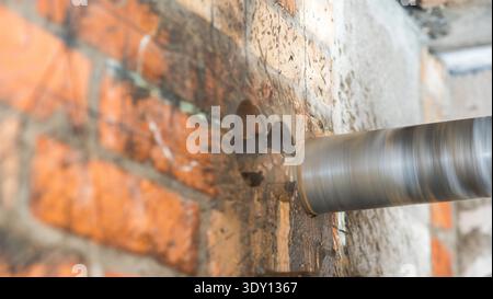 Core drilling machine drilling hole in brick wall during construction work Stock Photo