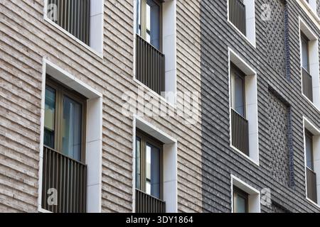 Modern brick facade with textured cladding and windows Stock Photo