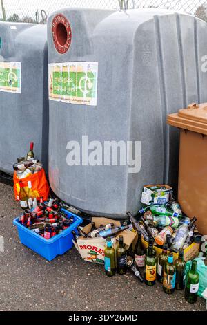 Full recycling bins with bottles left beside, Nethy Bridge, Scotland, UK Stock Photo