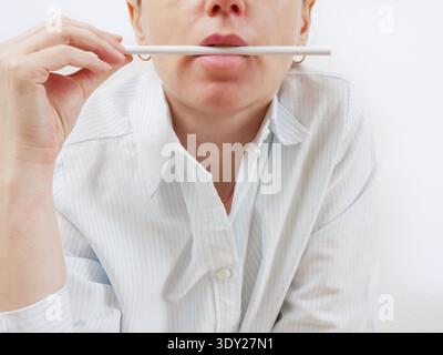 Exam Preparation. Frustrated Student with Puffed Cheeks Holding Pencil Near Mouth Expressing Burnout Stress and Fatigue During Exam Season Stock Photo