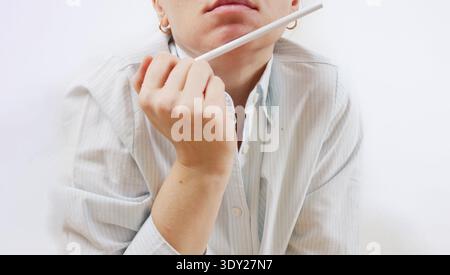 Exam Preparation. Focused Student Holding Pencil Horizontally Near Mouth in Deep Concentration During Exam Problem Solving Stress and Study Pressure Stock Photo