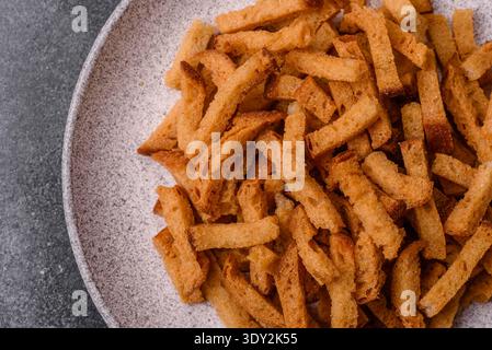 Croutons or crackers made from rye bread with garlic, salt, and spices, a salad ingredient. Croutons with salt and garlic as a food background for you Stock Photo