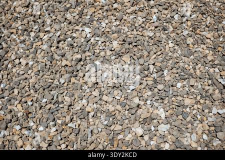 Rough gravel texture forming a natural background with small gray and tan stones Stock Photo