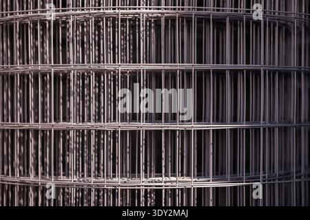 Rolled welded wire mesh fencing material creating abstract geometric pattern Stock Photo