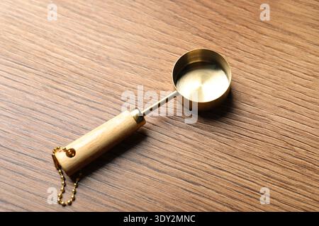 Golden scoop on wooden table, above view Stock Photo