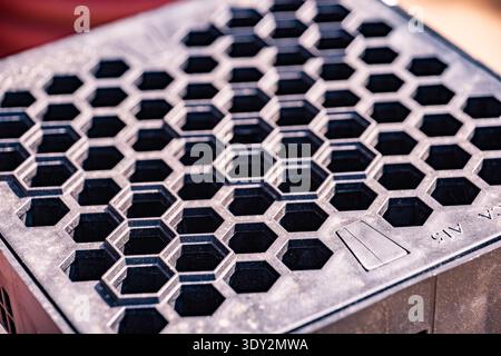 Repeating honeycomb pattern creating textured grid on black plastic surface Stock Photo