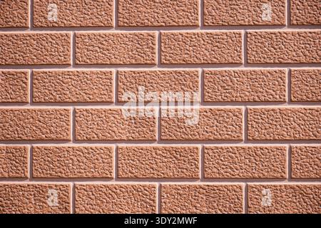 Brown textured brick wall surface creating a repeating pattern and background Stock Photo
