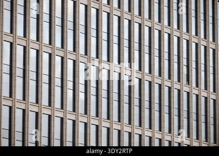 Modern building facade with repeating glass windows creating abstract geometric pattern Stock Photo