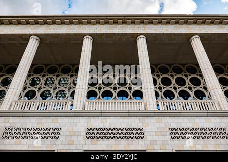 Modernist building facade featuring classical columns and geometric circular windows Stock Photo