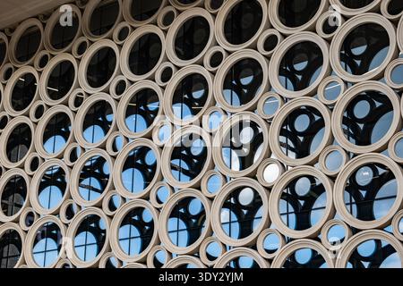 Modern building facade featuring abstract circular pattern and glass windows Stock Photo