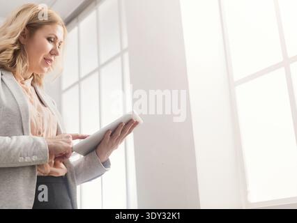 Happy businesswoman at work using digital tablet Stock Photo