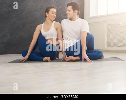 Young couple practicing yoga together in studio Stock Photo