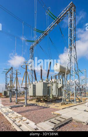 Vertical view of an outdoor electrical distribution substation, without people, at daytime on a background of a clear blue sky Stock Photo