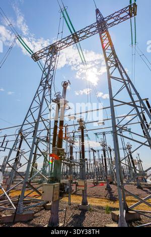Vertical view of an outdoor electrical distribution substation, without people, at daytime on a background of a clear blue sky Stock Photo