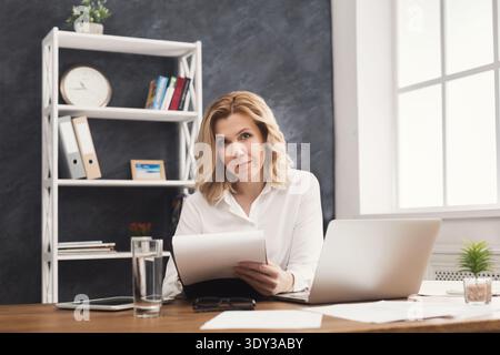 Business woman reading document at office desktop Stock Photo
