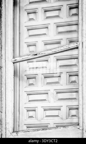 A high-key view of a wooden shutter that is hanging askew on the outside of a building in Madrid. Stock Photo