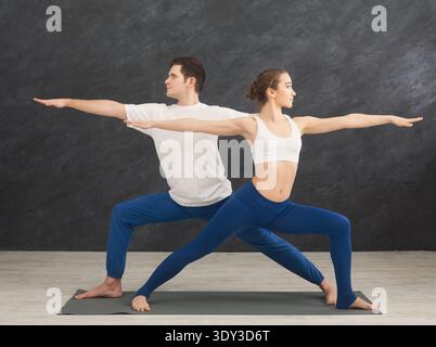 Young couple practicing yoga together in gym Stock Photo