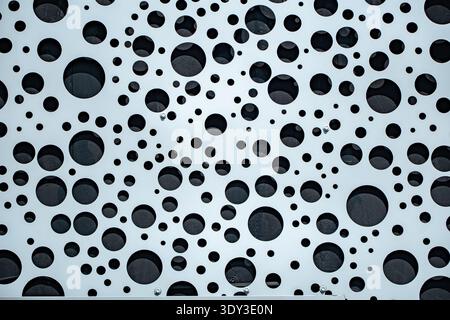 Perforated metal panel creating a contemporary abstract circle background Stock Photo