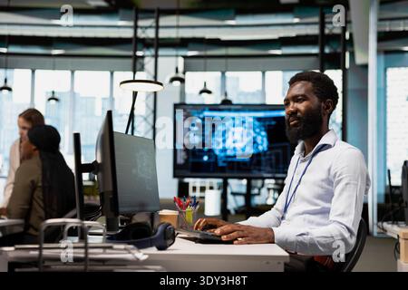 System administrator writing code, developing machine learning APIs. African american man in office troubleshooting application errors using artificial intelligence tech on green screen computer Stock Photo