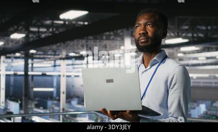 Technicians on data center industrial platform analyzing performance outputs after completing software updates. Server hub engineering team finetuning server rig configurations Stock Photo