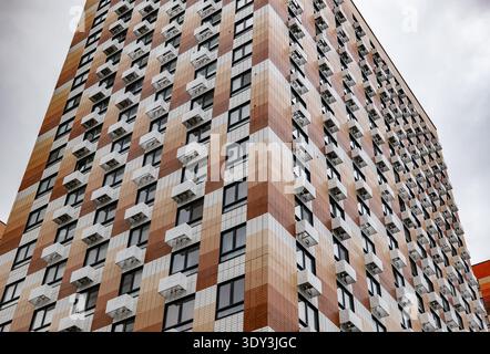 Modern building facade with checkerboard pattern, many windows and air conditioners Stock Photo