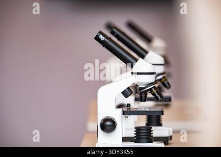 Row of microscopes in a laboratory setting, showing scientific research and education Stock Photo
