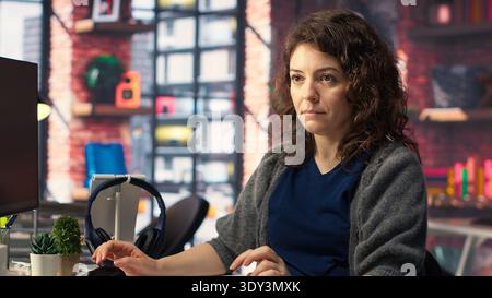 IT technician writing code and debugging on artificial intelligence neural networks computerized brain model. Female tech support doing checkup on AI systems, cloud computing. Camera B. Stock Photo
