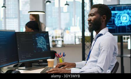 Software developer writing code on PC, developing deep learning APIs. IT professional using computer to troubleshoot software errors using artificial intelligence technology, camera A Stock Photo