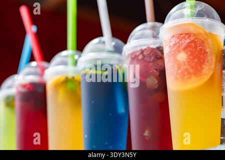 Colorful refreshing fruit drinks in plastic cups with straws, perfect for summer Stock Photo