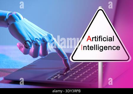 Robot using laptop. Sign with text Artificial Intelligence Stock Photo