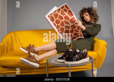Woman on sofa posing in studio Stock Photo