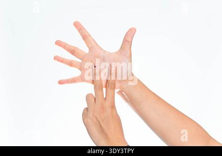 A detailed shot of an Indonesian woman's hands communicating using sign language gestures, isolated on a clean and plain white background. Stock Photo