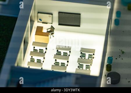 Miniature classroom interior model showing desks, chairs, teacher's desk, and whiteboards Stock Photo