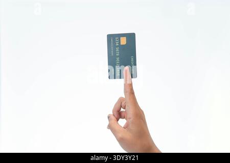 Close up of a hand pinching a black generic credit card between index and middle finger, isolated on white background. Stock Photo