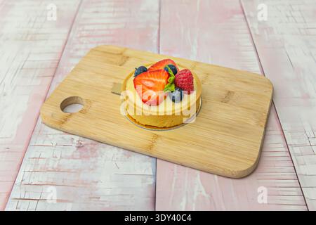 delicate fresh fruit tarts where color and geometry combine on a perfectly golden shortcrust pastry base. Image of individual tarts decorated with a f Stock Photo