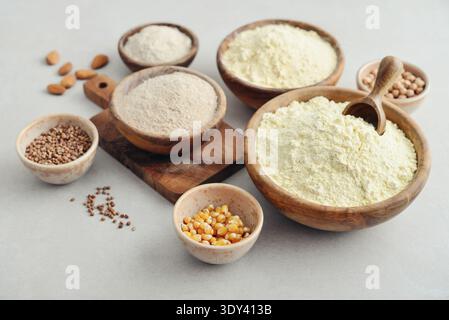 Wooden bowls with different types of gluten free flour and ingredients on light background, closeup Stock Photo