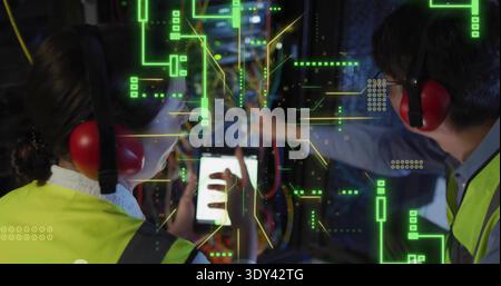 Working two technicians in hivis vests, red muffs, using tablet routing rack cables with AR overlay Stock Photo