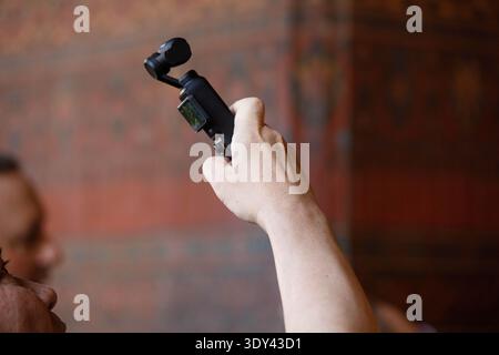 BANGKOK, THAILAND-FEB 7, 2026: Male tourist hand recording video inside temple, digital lifestyle in city, close up, at Wat Pho Temple. Stock Photo