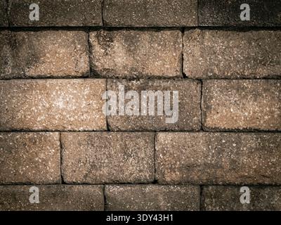 Close-up of textured brown brick wall showing rough surfaces and natural detail, ideal for architecture and background design Stock Photo