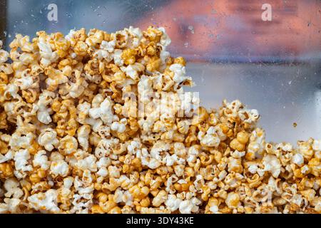 Caramel popcorn pile close-up in a clear display case Stock Photo
