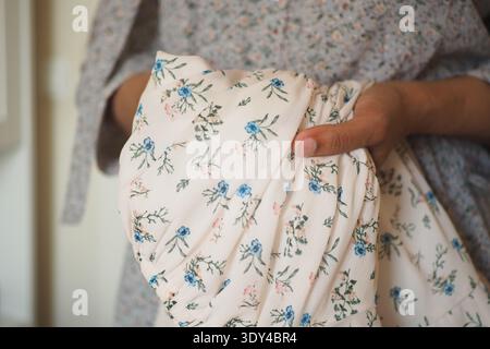 Holding a floral fabric in a light room Stock Photo